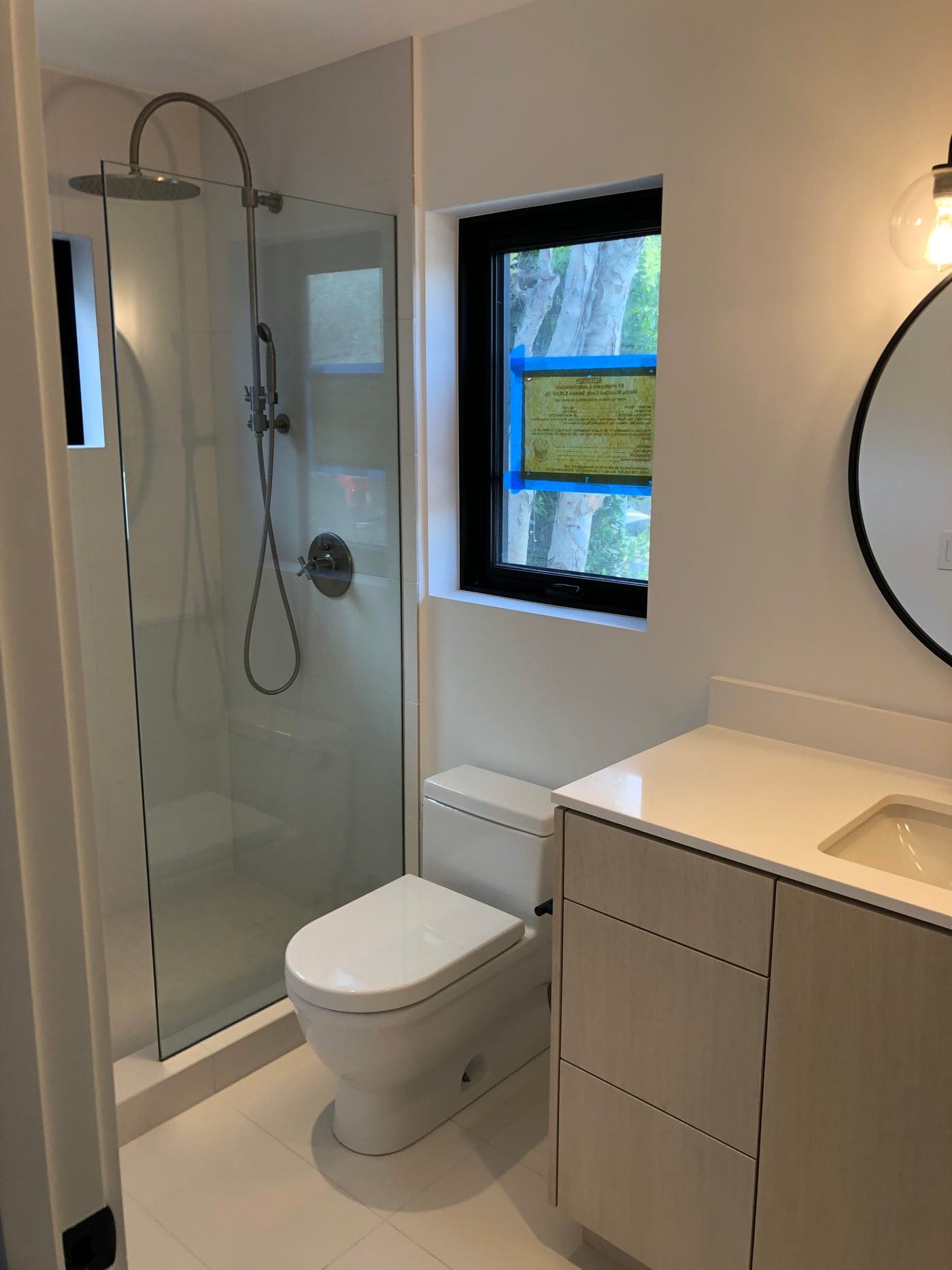 Malibu bathroom by Accelerate Construction with a frameless glass walk-in shower, an oak floating vanity with quartz counter and a wall-mounted toilet