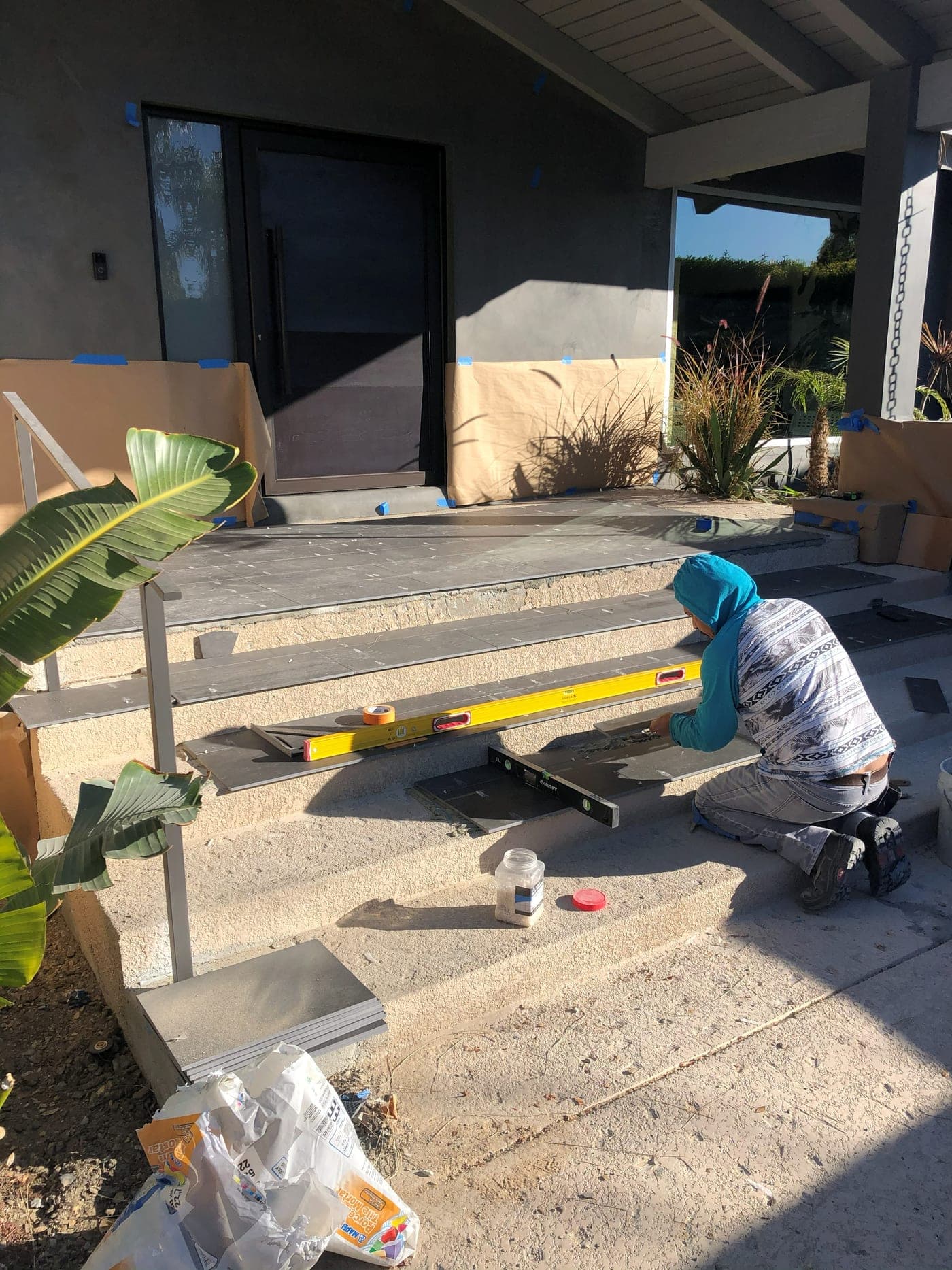 Stone tile being laid on the new patio and steps of the Los Angeles exterior project