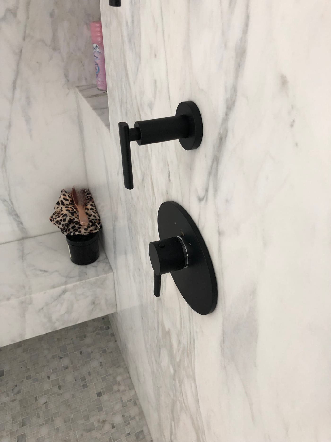 Black shower fixtures set in Calacatta marble in a Pacific Palisades bathroom by Accelerate Construction