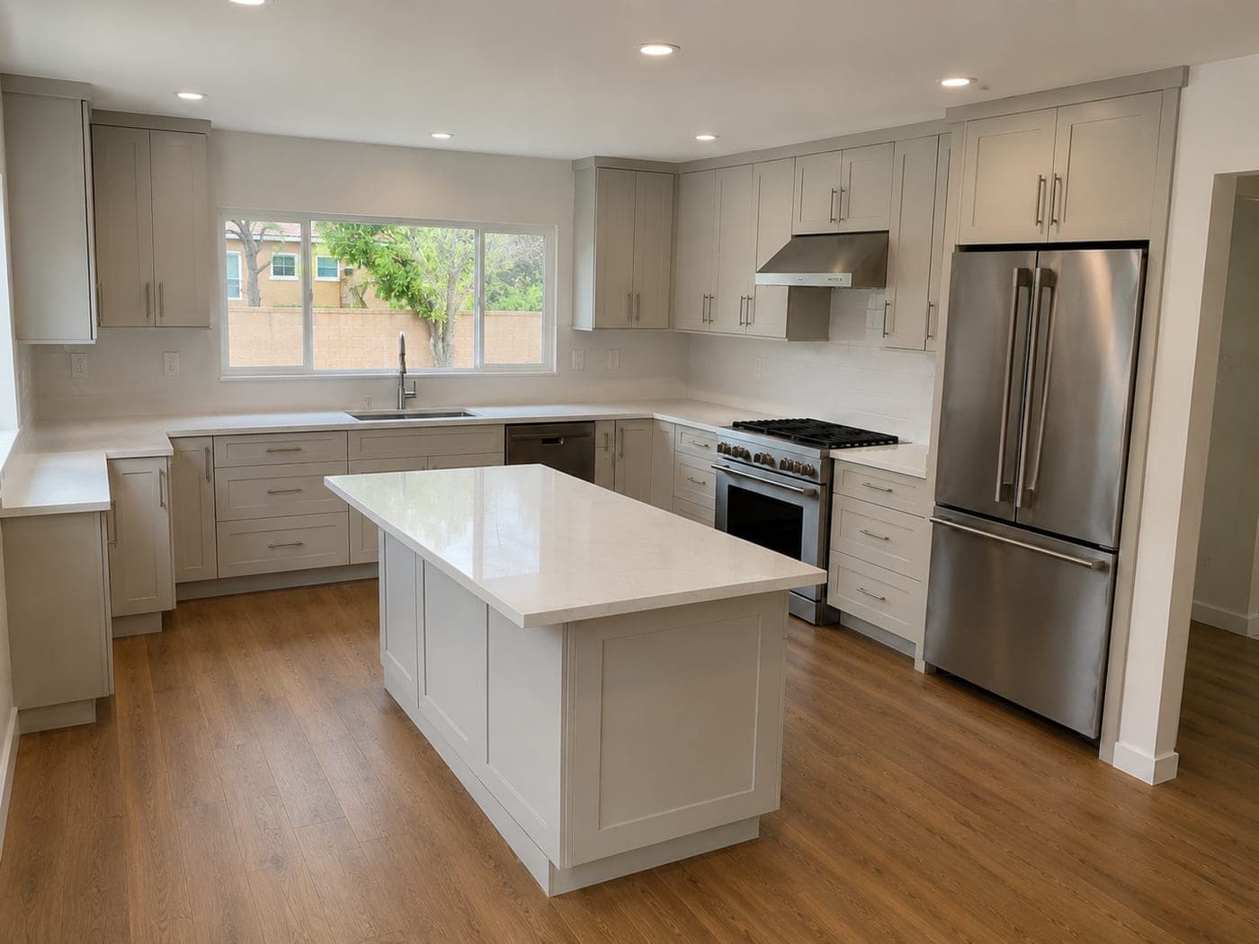 Studio City kitchen by Accelerate Construction with light gray shaker cabinetry, white quartz counters and a large center island