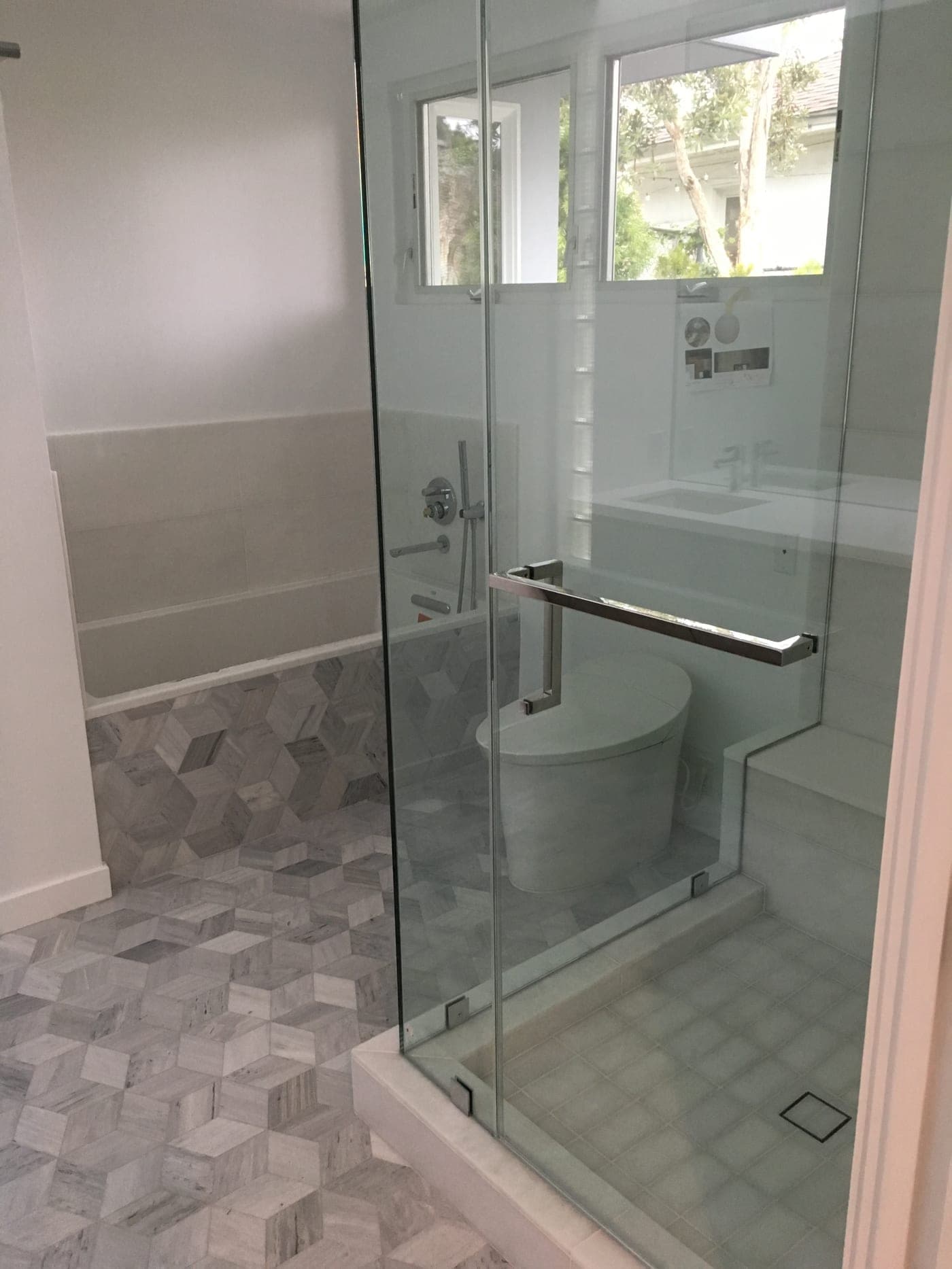 Santa Monica bathroom by Accelerate Construction with a frameless glass walk-in shower and a geometric marble-mosaic floor