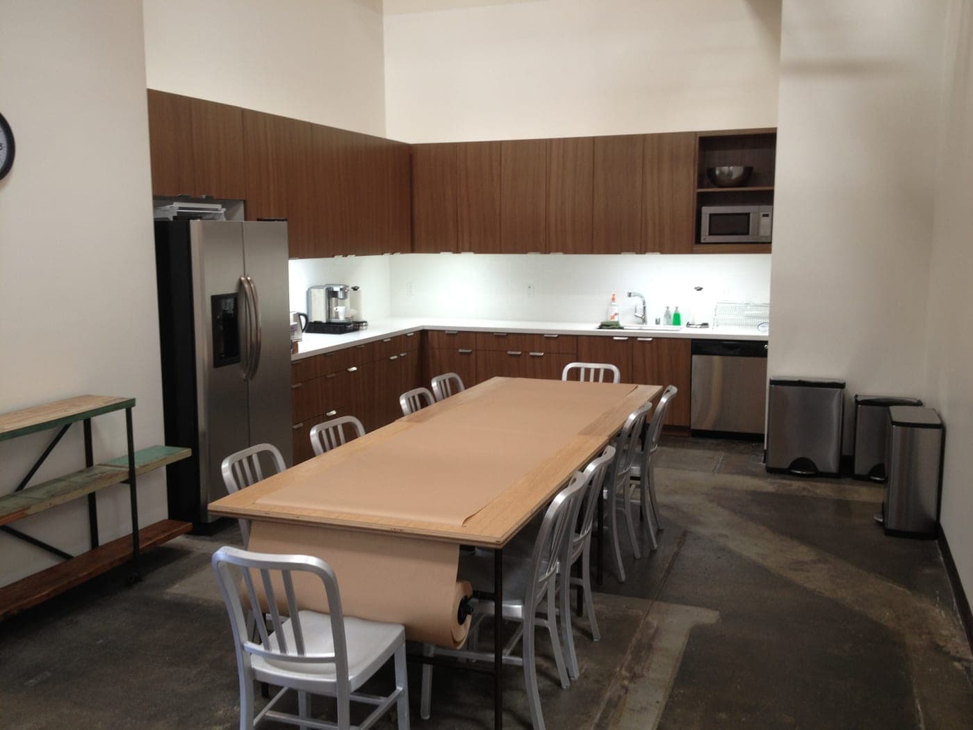 A finished interior of the Santa Monica commercial tenant improvement: a long table, chairs and built-in kitchen cabinetry