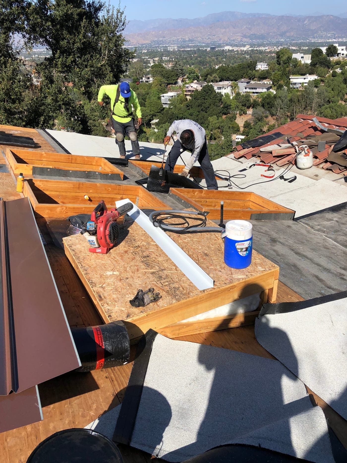 Crew tying the new roof of a Studio City addition into the existing tile roof, by Accelerate Construction