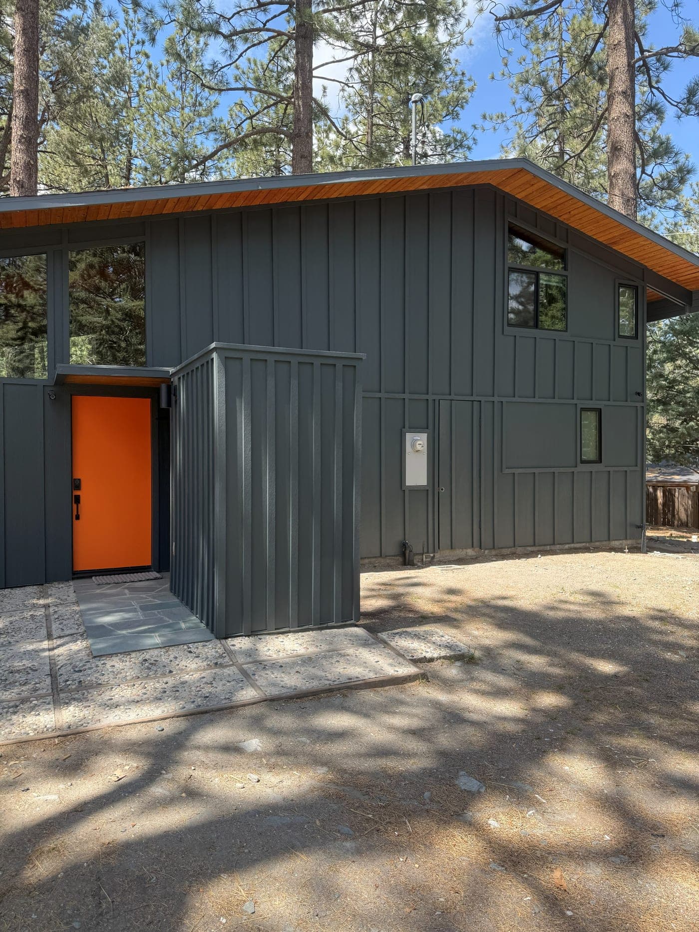 The renovated Wrightwood mountain home with new board-and-batten siding and an orange front door